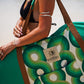 This image features a person standing on a sandy beach with a surfboard cover designed to resemble a lush, green aquatic scene, capturing the essence of the coastline. The surfboard cover, in shades of green, is patterned to mimic the natural hues found along the South Australian coast.
